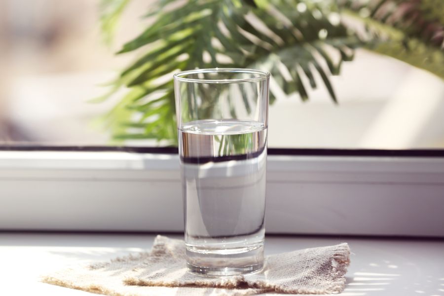 A glass of alkaline water on a window sill