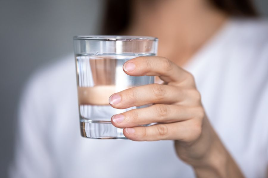 A hand holding a glass of water