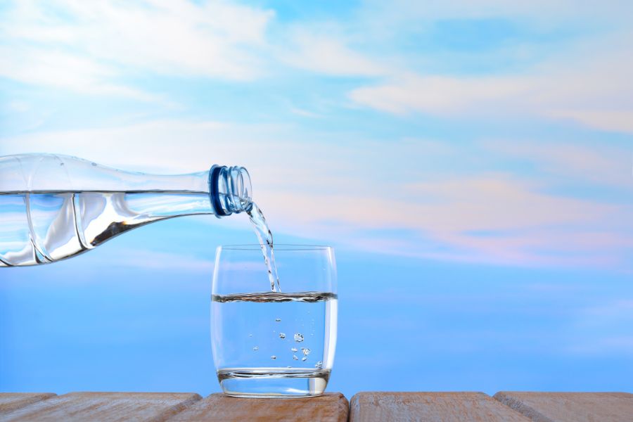 A glass of water being poured into a glass